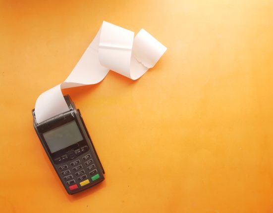 a cell phone sitting on top of a table next to a roll of paper
